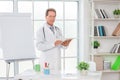 Senior doctor at his office in hospital working holding digital tablet Royalty Free Stock Photo