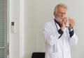 Senior doctor male prepare giving vaccine with injection or syringe to scared patient at hospital Royalty Free Stock Photo