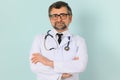 Senior doctor man wearing stethoscope and medical coat oveer blue background Royalty Free Stock Photo