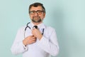 Senior doctor man wearing stethoscope and medical coat oveer blue background Royalty Free Stock Photo