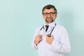 Senior doctor man wearing stethoscope and medical coat oveer blue background Royalty Free Stock Photo