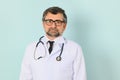 Senior doctor man wearing stethoscope and medical coat oveer blue background Royalty Free Stock Photo