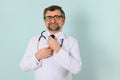 Senior doctor man wearing stethoscope and medical coat oveer blue background Royalty Free Stock Photo