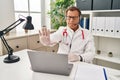 Senior doctor man working on online appointment doing stop sing with palm of the hand Royalty Free Stock Photo
