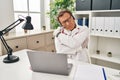 Senior doctor man working on online appointment hugging oneself happy and positive, smiling confident Royalty Free Stock Photo