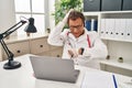 Senior doctor man working on online appointment looking at the watch time worried, afraid of getting late Royalty Free Stock Photo