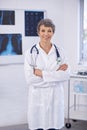 Senior doctor, woman and arms crossed in portrait, radiology for surgery with anatomy scan and healthcare. Medical Royalty Free Stock Photo