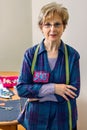 Senior dressmaker posing with sewing materials