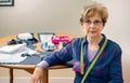 Senior dressmaker posing with sewing materials