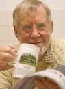 Senior drinking tea and reading newspaper. Royalty Free Stock Photo