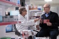 Senior drugstore client selecting heart health supplements in pharmacy