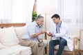 Senior elder asian man asking young caucasian doctor about indications and contraindications of new medicine, healthcare and Royalty Free Stock Photo