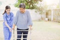 senior elderly adult woman with disability using walker walk practice in home care nurse doctor or physiotherapist help support