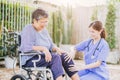 senior elderly adult woman with disability wheelchair in home care nurse doctor or physiotherapist help support relax outdoor Royalty Free Stock Photo