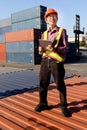 A senior elderly Asian worker engineer wearing safety vest and helmet standing and holding digital tablet at shipping cargo