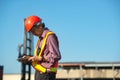 A senior elderly Asian worker engineer wearing safety vest and helmet standing and holding digital tablet at shipping cargo