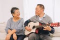 Senior elderly couple lover holiday home activity old man playing guitar music make elder wife happy smile Royalty Free Stock Photo