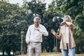 Senior elderly couple man with big laughing and surprised or excited woman in the park. Happy retired life of older people. Marria