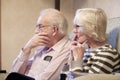 Senior elderly couple watching the news on TV concerned of the Coronavirus spread Royalty Free Stock Photo