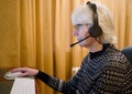 Senior elderly lady using headset earphones and microphone to talk to family on a computer Royalty Free Stock Photo