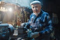 Senior elderly male turner mechanic working on machine tool for metal