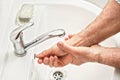 Senior elderly man his hands and wrist with soap under tap water faucet, detail photo. Can be used as hygiene illustration concept