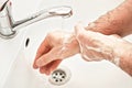 Senior elderly man his hands and wrist with soap under tap water faucet, detail photo. Can be used as hygiene illustration concept