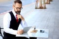 Senior elderly mature business man using digital table during having a coffee at outdoor cafe, happy people taking a break from Royalty Free Stock Photo