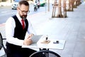 Senior elderly mature business man using digital table stressful thinking about work during having coffee at outdoor cafe, serious