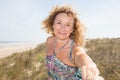 Senior elderly woman give hand to man lover on sand beach