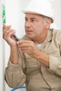senior electrician using screwdriver on wall socket Royalty Free Stock Photo