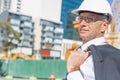 Senior elegant builder man in suit at construction site on sunny summer day Royalty Free Stock Photo