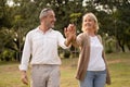 Senior elegant caucasian couple dancing looking at each other feeling love and cherish on their anniversary in the park with copy Royalty Free Stock Photo