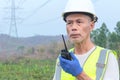 A senior engineer inspects a high-voltage power pole