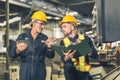 senior engineer talking explain machine working process for teaching training young male worker at heavy industry factory