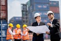 Senior engineers describe details of project to young woman customers at work site, Construction manager and engineer working on Royalty Free Stock Photo