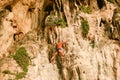 A senior man free solo climber hangs on the cliff of Rai Leh