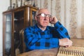 senior European man sitting at the table and thinking about memories medium closeup indoor seniority concept Royalty Free Stock Photo