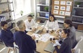 Employees listening to senior executive sitting around office table in corporate meeting Royalty Free Stock Photo