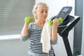 Senior exercising with weights at home. Corona virus, Covid-19, stay at home, active seniors, home quarantine concept Royalty Free Stock Photo