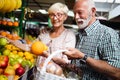 Senior family couple choosing bio food fruit and vegetable on the market during weekly shopping Royalty Free Stock Photo