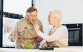 Senior Family Couple Feeding Each Other Cooking Dinner In Kitchen Royalty Free Stock Photo