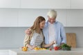 Senior family couple and pretty adult daughter preparing healthy dinner Royalty Free Stock Photo