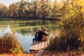 Senior family couple relaxing by autumn lake. Man and woman enjoying nature and hugging sitting on pier Royalty Free Stock Photo