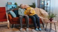 Senior family couple man woman enjoying reading interesting book, talking, laughing at home on sofa Royalty Free Stock Photo