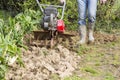 Senior farmer gardener working in the garden with rototiller , tiller tractor, cutivator, miiling machine Royalty Free Stock Photo