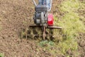 Senior farmer gardener working in the garden with rototiller , tiller tractor, cutivator, miiling machine