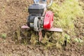 Senior farmer gardener working in the garden with rototiller , tiller tractor, cutivator, miiling machine Royalty Free Stock Photo