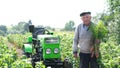 Senior farmer shows the harvest in the field in summer.