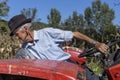 Senior farmer using an old tractor to plow his land Royalty Free Stock Photo